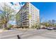 Exterior view of a high-rise building at a street corner with mature trees and visible city traffic and blue skies at 800 N Washington St # 804, Denver, CO 80203