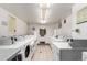 Clean and well-lit laundry room with multiple high-efficiency washing machines, white walls, and tiled flooring at 800 N Washington St # 804, Denver, CO 80203
