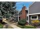 Townhome featuring gray siding, a brick chimney, and well maintained landscaping at 6625 W 84Th Cir # 48, Arvada, CO 80003