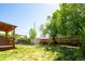 Lush backyard featuring a deck, mature trees, a cozy hammock, and a convenient storage shed at 1735 S Wyandot St, Denver, CO 80223