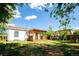 Spacious backyard with a covered deck, grassy area, mature trees, and a swing set for outdoor enjoyment at 1735 S Wyandot St, Denver, CO 80223