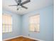Bedroom with hardwood floors and a ceiling fan, lit by natural light from two windows at 1735 S Wyandot St, Denver, CO 80223