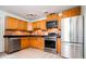 Traditional kitchen with stainless steel appliances, oak cabinetry, and black countertops at 1735 S Wyandot St, Denver, CO 80223