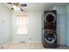 Bright laundry room features tiled floor, a window, and modern stackable washer and dryer at 1735 S Wyandot St, Denver, CO 80223