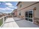 Back deck with stone accents, railing, and a sliding glass door to the home's interior at 19347 E 65Th Ave, Aurora, CO 80019