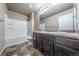 Bathroom featuring double vanity with white sinks, tiled shower and tub, and neutral walls at 19347 E 65Th Ave, Aurora, CO 80019