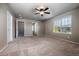 Spacious bedroom with carpeted floor, ceiling fan, multiple windows, and an ensuite bathroom at 19347 E 65Th Ave, Aurora, CO 80019