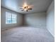 Large bedroom featuring a ceiling fan, neutral colors, plush carpet, and natural light at 19347 E 65Th Ave, Aurora, CO 80019