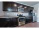 Contemporary kitchen with stainless steel appliances and dark cabinets at 19347 E 65Th Ave, Aurora, CO 80019