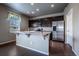Dark cabinets, stainless steel appliances, island, and hardwood floors in this contemporary kitchen at 19347 E 65Th Ave, Aurora, CO 80019