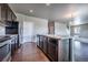 Kitchen and dining area featuring dark cabinets, stainless appliances, and hardwood floors at 19347 E 65Th Ave, Aurora, CO 80019