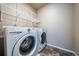 Laundry room features modern washer and dryer, with wire rack shelving and a tiled floor at 19347 E 65Th Ave, Aurora, CO 80019
