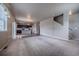 Open-concept living room with a view of the modern kitchen, hardwood floors, carpet, and staircase at 19347 E 65Th Ave, Aurora, CO 80019