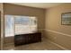 Cozy bedroom with a wooden dresser, large window with blinds, and neutral-colored walls at 8430 Little Rock Way # 102, Highlands Ranch, CO 80126