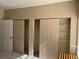 Bedroom featuring three closets with sliding doors and ample storage space at 8430 Little Rock Way # 102, Highlands Ranch, CO 80126