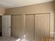 Bedroom view showcasing three closets with sliding doors and plenty of storage at 8430 Little Rock Way # 102, Highlands Ranch, CO 80126