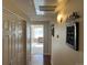 Hallway with closet, art, and wood floors leading to a sunny room at 8430 Little Rock Way # 102, Highlands Ranch, CO 80126