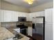 Modern kitchen boasting granite countertops, stainless steel appliances, and bright white cabinetry at 8430 Little Rock Way # 102, Highlands Ranch, CO 80126