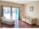 Bright living room with an open door to the outside and comfortable seating and beautiful hardwood floors at 8430 Little Rock Way # 102, Highlands Ranch, CO 80126