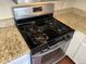 Modern stainless steel stove with four burners and digital display in a well-lit kitchen at 8430 Little Rock Way # 102, Highlands Ranch, CO 80126