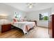 Bright bedroom featuring wood floors, two windows, and stylish decor at 11880 W 30Th Pl, Lakewood, CO 80215