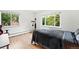 Minimalist bedroom with hardwood floors, two windows, and modern decor at 11880 W 30Th Pl, Lakewood, CO 80215