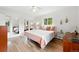 Sunlit bedroom boasts hardwood floors, mirrored closet doors, and soft, stylish accents at 11880 W 30Th Pl, Lakewood, CO 80215