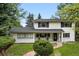 Inviting two-story home showcasing a manicured lawn and brick pathway leading to the covered front porch at 11880 W 30Th Pl, Lakewood, CO 80215