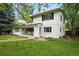 Charming two-story home featuring a brick-and-wood facade and a welcoming front porch, surrounded by lush greenery at 11880 W 30Th Pl, Lakewood, CO 80215