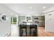 Bright kitchen featuring an island with seating, stainless steel appliances, and a view of the outdoor patio at 11880 W 30Th Pl, Lakewood, CO 80215