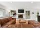 Cozy living room with a fireplace, built-in cabinets, hardwood floors, and a large leather sofa for comfortable seating at 11880 W 30Th Pl, Lakewood, CO 80215
