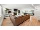 Open-concept living room with a fireplace, built-in shelving, and hardwood floors, flowing into the kitchen area at 11880 W 30Th Pl, Lakewood, CO 80215