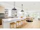 Bright, modern kitchen features a large island with seating, open shelves, and seamless access to the dining area at 2736 N Clay St, Denver, CO 80211