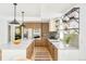 Modern kitchen featuring a large island, wood cabinets, and stainless steel appliances at 2736 N Clay St, Denver, CO 80211