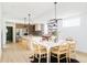 An open-concept kitchen and dining area with a large island, sleek appliances, and contemporary lighting fixtures at 2736 N Clay St, Denver, CO 80211