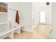 Mud room with white built-in shelving, bench, hooks and light hardwood floors at 2736 N Clay St, Denver, CO 80211