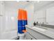 Well-lit bathroom featuring a shower with blue and orange Denver Broncos-themed curtain, sink, and gray counter at 14952 Gladshine Dr, Parker, CO 80134