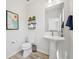 Tastefully decorated half bathroom features a pedestal sink, modern fixtures, and mountain artwork at 14952 Gladshine Dr, Parker, CO 80134