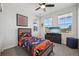 Bright bedroom featuring a ceiling fan, three windows, and a bed with a Denver Broncos theme at 14952 Gladshine Dr, Parker, CO 80134