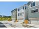 Contemporary townhomes with varied colors and attached garages create an inviting streetscape at 14952 Gladshine Dr, Parker, CO 80134