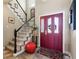 Foyer with a view of the staircase and a striking red front door at 8559 W 93Rd W Ct, Broomfield, CO 80021