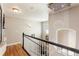 Well-lit hallway with hardwood floors, a decorative light fixture, and white wainscoting at 8559 W 93Rd W Ct, Broomfield, CO 80021