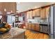 This open kitchen showcases stainless steel appliances, granite counters, a mosaic backsplash, and hardwood floors at 8559 W 93Rd W Ct, Broomfield, CO 80021
