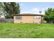 Backyard with lawn and fence. Back of home is visible with windows and tan siding at 10505 Lowry Pl, Aurora, CO 80010