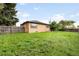 Fenced backyard and lawn. Back of home is visible with windows and tan siding at 10505 Lowry Pl, Aurora, CO 80010