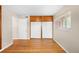Bedroom featuring hardwood floors, neutral walls, and built-in closet storage at 10505 Lowry Pl, Aurora, CO 80010