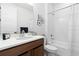 Clean bathroom with a modern vanity, white tile shower, and bathtub combination at 5211 Routt Ct, Arvada, CO 80002