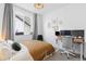 Bright bedroom with a large window, modern decor, and a functional desk area at 5211 Routt Ct, Arvada, CO 80002