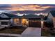 Charming single-Gathering home featuring stone accents and a well-manicured lawn at dusk at 5211 Routt Ct, Arvada, CO 80002