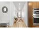 Bright hallway with hardwood floors, modern decor, and access to the kitchen at 5211 Routt Ct, Arvada, CO 80002